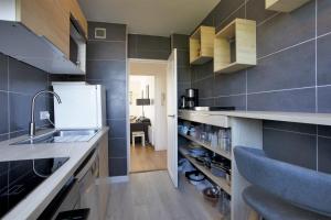 a kitchen with a sink and a counter at Appartement des Chênes - Welkeys in Anglet
