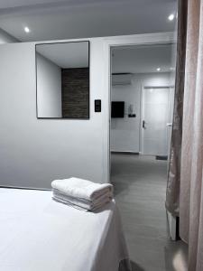 a white room with a bed and a mirror at New apartment in Al Hoceïma +3 photos