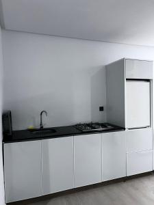 a white kitchen with a sink and a refrigerator at New apartment in Al Hoceïma