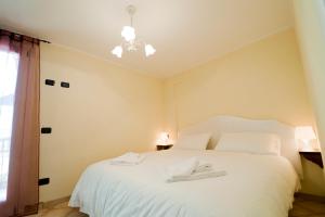 - une chambre avec un lit blanc et 2 serviettes dans l'établissement Residence La Corte, à Vezza dʼOglio