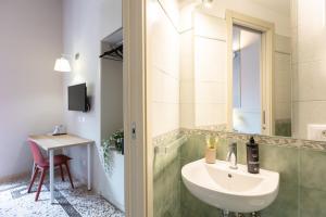 Un baño con lavabo, espejo y mesa. en Iron Cityaus Termini, en Roma 52 fotos más