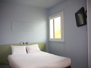 1 dormitorio con 1 cama y TV en la pared en ibis budget Thonon Les Bains, en Thonon-les-Bains