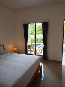 une chambre avec un lit et une vue sur une piscine dans l'établissement Pulmo Residen Canggu, à Canggu
