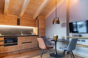 a kitchen with wooden walls and a table and chairs at LIVIN JOY Bivio Travel in Livigno +7 photos