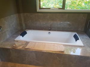 una vasca da bagno bianca seduta su un bancone in bagno di Montrose Barn House- Entire Home a Montrose Altre 19 foto