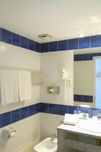 a bathroom with a sink and a toilet and a mirror at Hotel Blaumar Cadaqués by Fimedhotels in Cadaqués