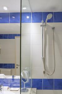 a shower in a bathroom with blue and white tiles at Hotel Blaumar Cadaqués by Fimedhotels in Cadaqués