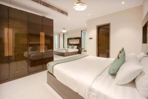 a bedroom with a large white bed and a couch at Zip By Spree Hotels Surat in Surat +39 photos