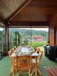 a large wooden table with chairs on a patio at Casa do Lago Pinhal in Rio dos Cedros