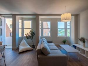 a living room with a couch and some windows at La Fantástica Pontedeume 2 in Puentedeume +25 photos