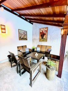 a living room with a wooden table and chairs at Anama by Queens Mount in Tangalle