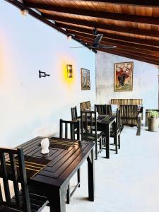 a dining room with wooden tables and chairs at Anama by Queens Mount in Tangalle