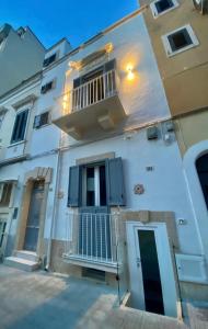 Edificio blanco con balcón y puerta en Dimora Quarto, en Monopoli