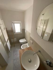 Un baño con lavabo, espejo e inodoro. en Dimora Quarto, en Monopoli 17 fotos más