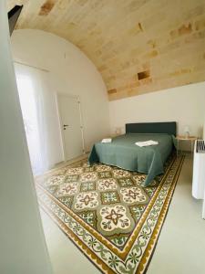 1 dormitorio con 1 cama verde y 1 alfombra en Dimora Quarto, en Monopoli