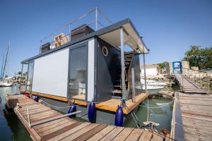圣玛丽亚港The Boathouse Company - Casa flotante experience - Real Club Náutico, El Puerto de Santa María的一艘小船停靠在码头