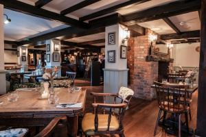 a restaurant with wooden tables and chairs and a brick wall at The Pilgrim Inn in Southampton