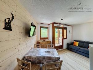 a living room with a table and a couch at Studio + cabine 4 pers 24m², ski aux pieds, parking à proximité - FR-1-178-106 in Les Menuires