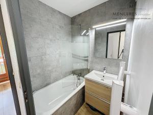 a bathroom with a white tub and a sink and a bath tub at Studio + cabine 4 pers 24m², ski aux pieds, parking à proximité - FR-1-178-106 in Les Menuires +12 photos