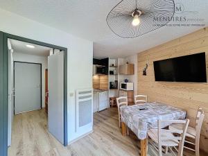 a kitchen and dining room with a table and a television at Studio + cabine 4 pers 24m², ski aux pieds, parking à proximité - FR-1-178-106 in Les Menuires
