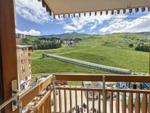a balcony with a view of a green field at Studio + cabine 4 pers 24m², ski aux pieds, parking à proximité - FR-1-178-106 in Les Menuires