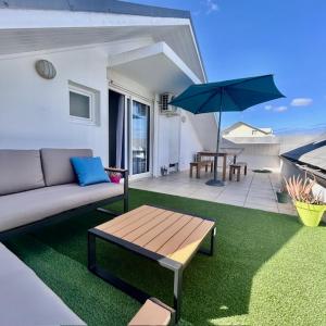 a living room with a couch and a table and an umbrella at Saint-leu Réunion centre ville T3 Duplex meublé in Saint-Leu