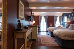 a hotel room with two beds and a table with a telephone at The Pilgrim Inn in Southampton