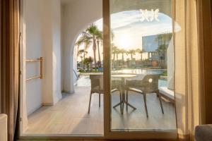 サアラ・デ・ロス・アトゥネスにあるZahara Beach & Spa by QHotels - Adults Recommendedのダイニングルーム(テーブル、ガラスドア付)