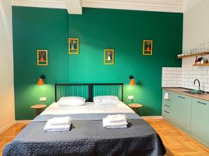 a bedroom with a bed with a green wall at Pirosmani Boutique Aparthotel in Tbilisi City
