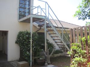 a staircase on the side of a house with a fence at 59 On Gail in Ballito