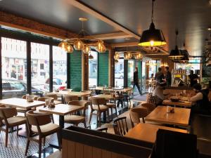 a restaurant with wooden tables and chairs and people in the background at Favoriten Apartments in Vienna