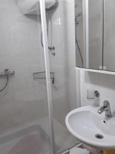 a white bathroom with a shower and a sink at Room Nada in Primošten