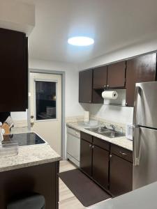 a kitchen with brown cabinets and a stainless steel refrigerator at Beautiful downtown Anchorage 2 in Anchorage