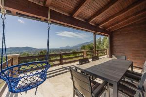 a porch with a swing and a table and chairs at Panora Oliva in Rap