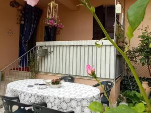 un tavolo bianco con sedie e un fiore rosa di Good Art a Strevi