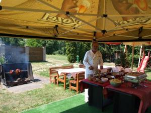 a man standing in front of a table with food at Hotel Kormoran in Zlenice 
