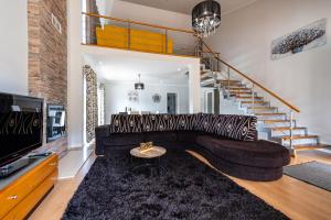 Una sala de estar con un sofá y una escalera. en Home Inn Green Caldera, en Furnas