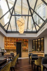 波尔多Villas Foch Boutique Hotel & Spa Bordeaux的配有桌椅和玻璃天花板的房间