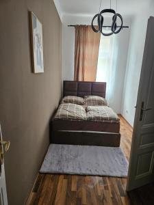 ein kleines Schlafzimmer mit einem Bett und einem Fenster in der Unterkunft Gold Appartman in Wien
