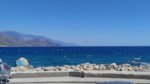 a view of the ocean with a car parked next to it at Spamandos Rooms in Palaiochora