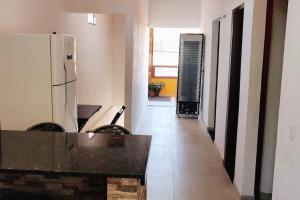 a kitchen with a refrigerator and a counter top at Casa do Sol Flecheiras in Trairi