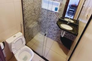 a bathroom with a toilet and a sink at Casa do Sol Flecheiras in Trairi +15 photos