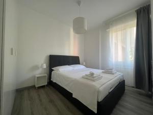 een slaapkamer met een bed met witte lakens en een raam bij Mare Mosso in Bordighera