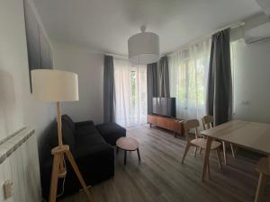 een woonkamer met een bank, een tafel en een tv bij Mare Mosso in Bordighera