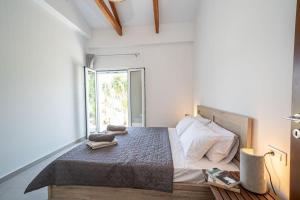 a bedroom with a bed and a large window at Villa Aionia in Lepeda in Lixouri