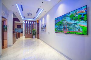 a hallway with a large flat screen tv on a wall at Villa HOÀNG GIA in Dong Hoi