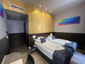 a hotel room with two beds and a table at Carat Boutique Hotel in Budapest