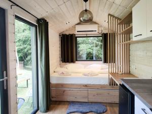 a bedroom in a tiny house with a large window at Transfăgărășan River Retreat in Arefu