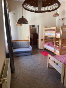 a room with two bunk beds and a blue couch at Penzión Duna & soľná jaskyňa in Komárno