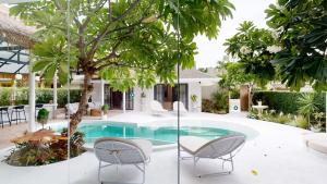 a courtyard with a pool and chairs and trees at Idyllic Samui Beach Villa Resort in Choeng Mon Beach